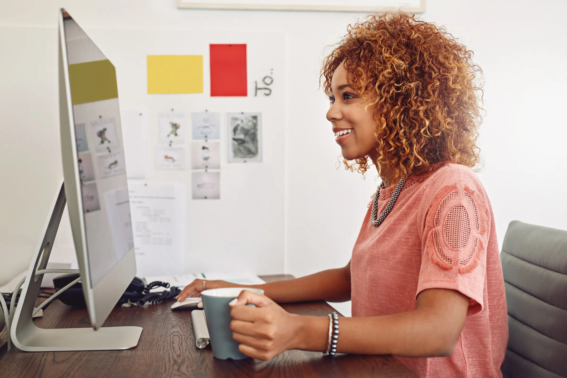 A content writer at a computer, researching and editing copy for a local-business website.