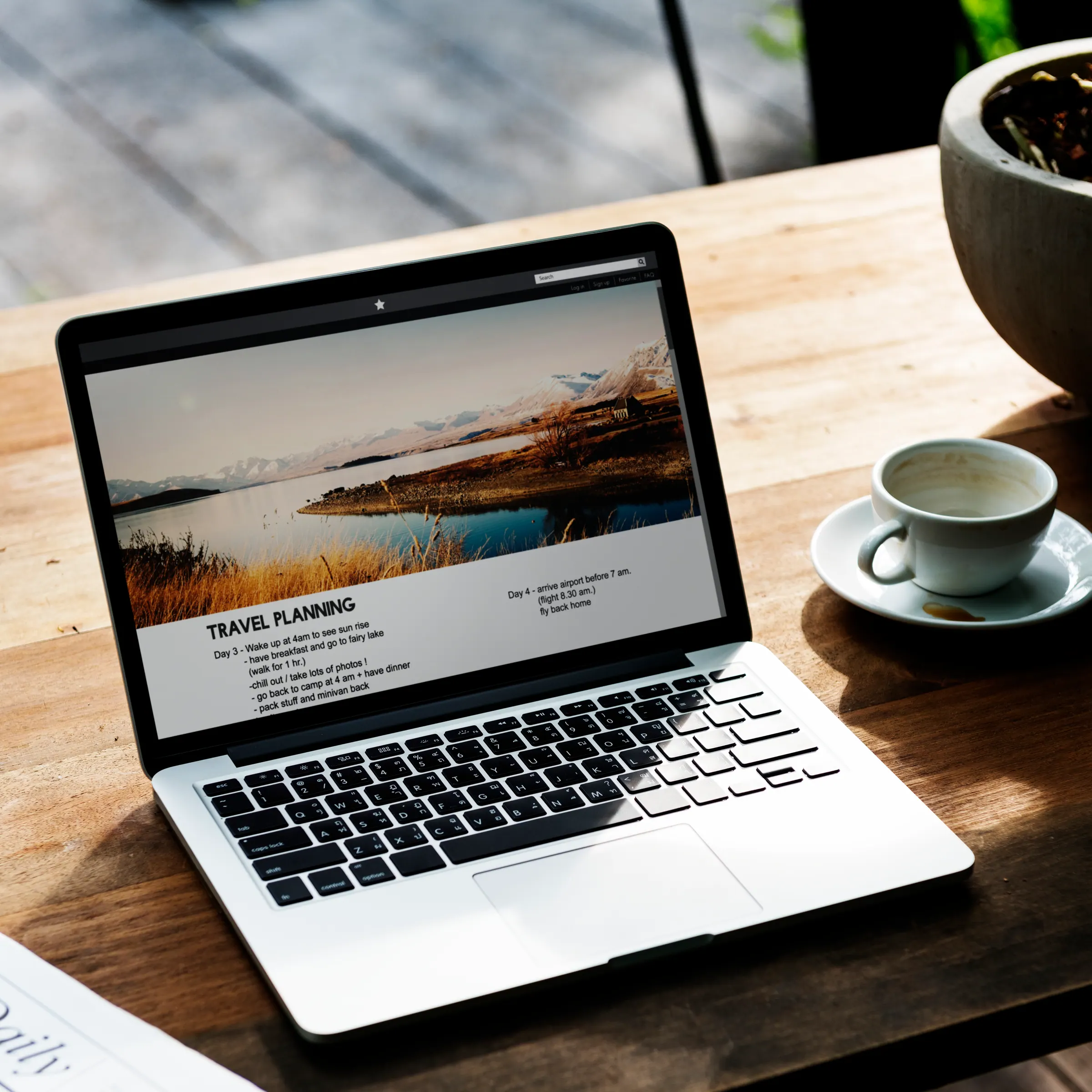 A laptop open on a wood desk in soft light — the digital storefront, working when no one is in the room.