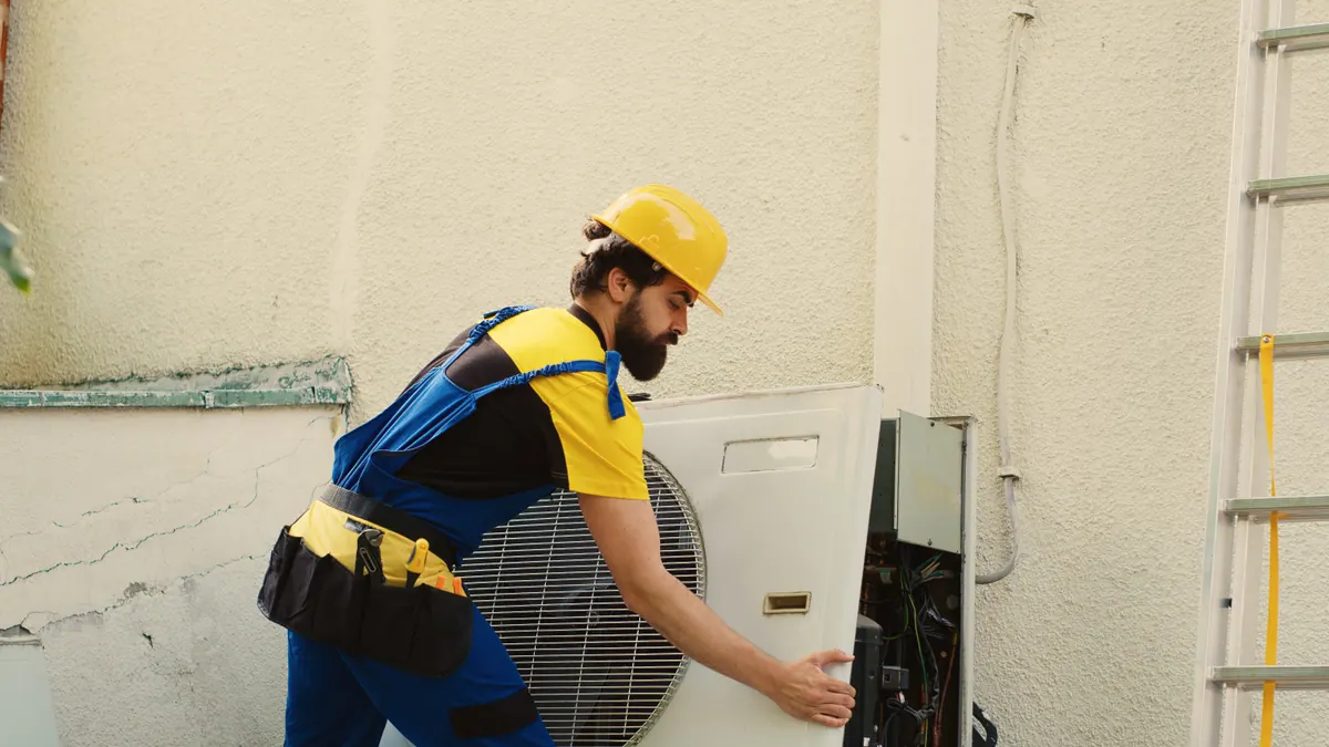 An HVAC technician servicing an air-conditioning unit — choosing the best HVAC company in Cedar Rapids.